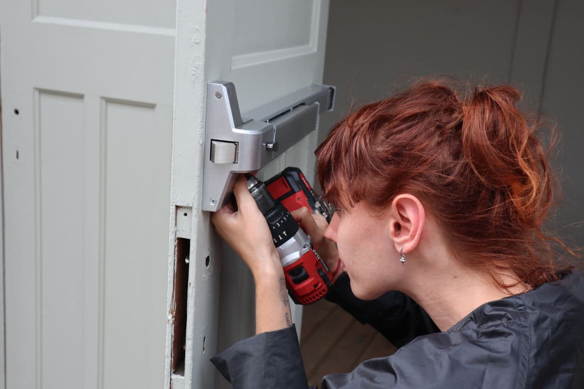 Artisan installant une serrure neuve à la perceuse, changement de serrure à Montpellier